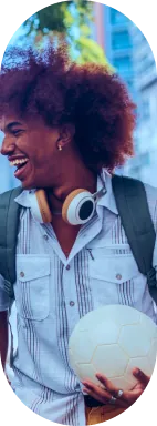 Estudante sorrindo com fones de ouvido e uma bola